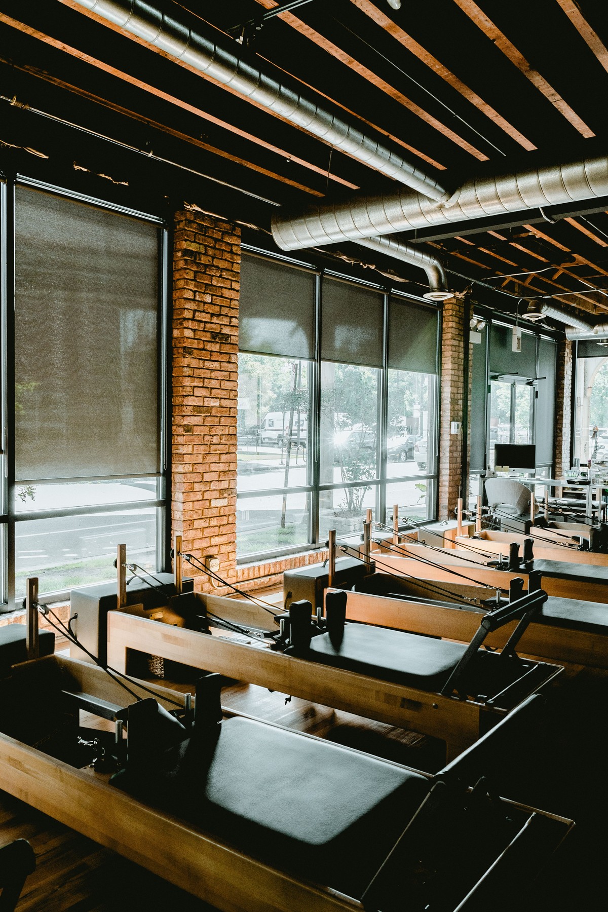 Sunlit boutique Pilates studio with wooden reformer equipment and mats