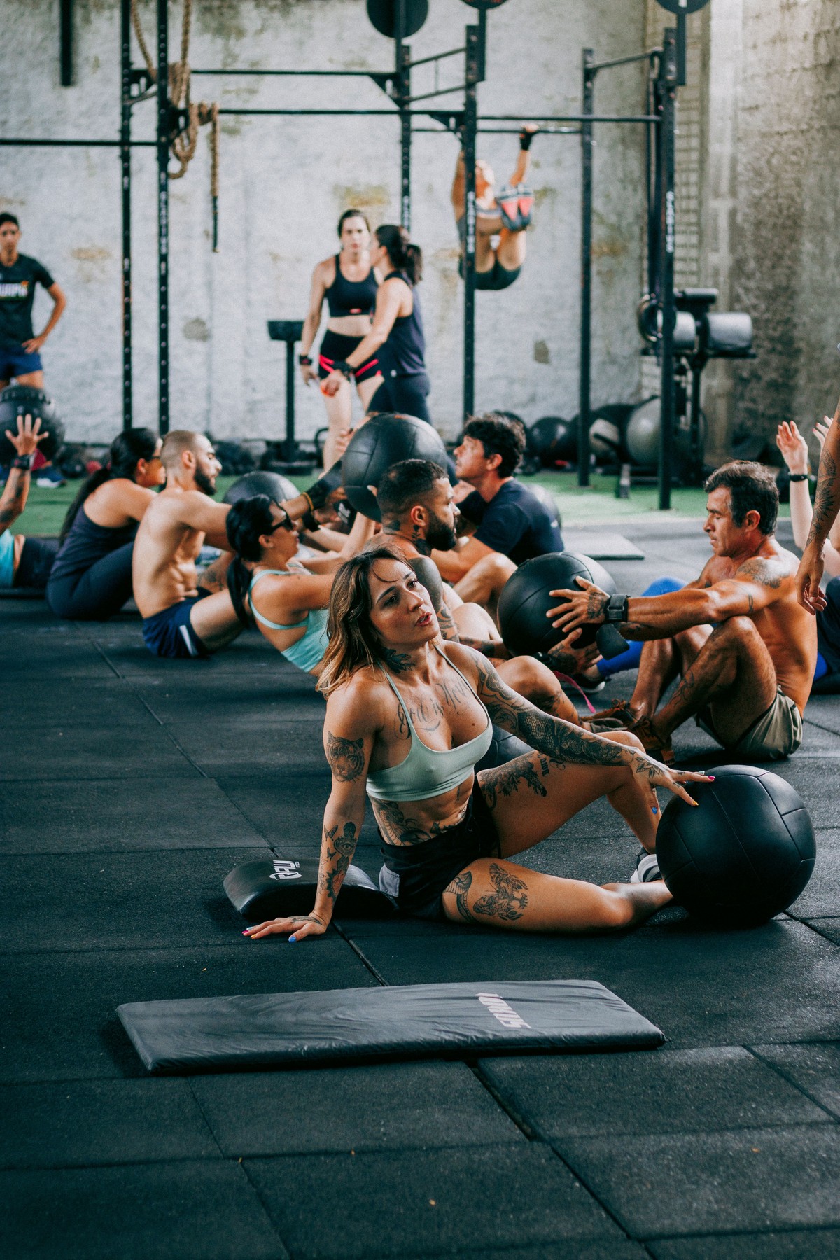 Adults participating in an energetic indoor CrossFit class with medicine balls