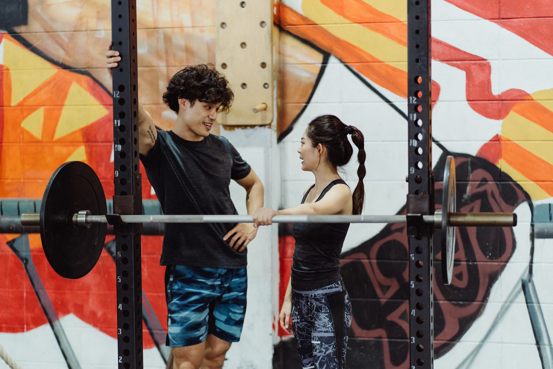 Two people talking beside gym equipment in a boutique fitness studio
