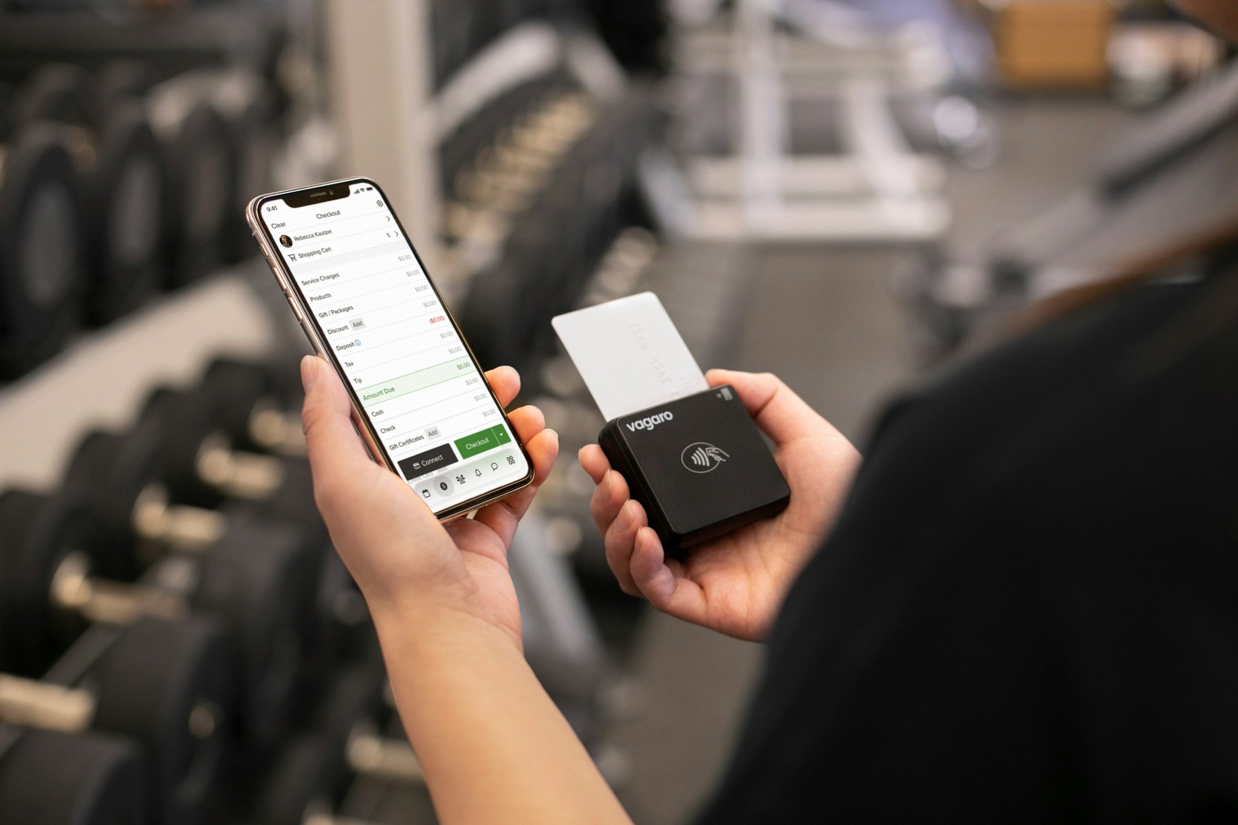 Gym staff member following up on a lead using a phone in a boutique studio