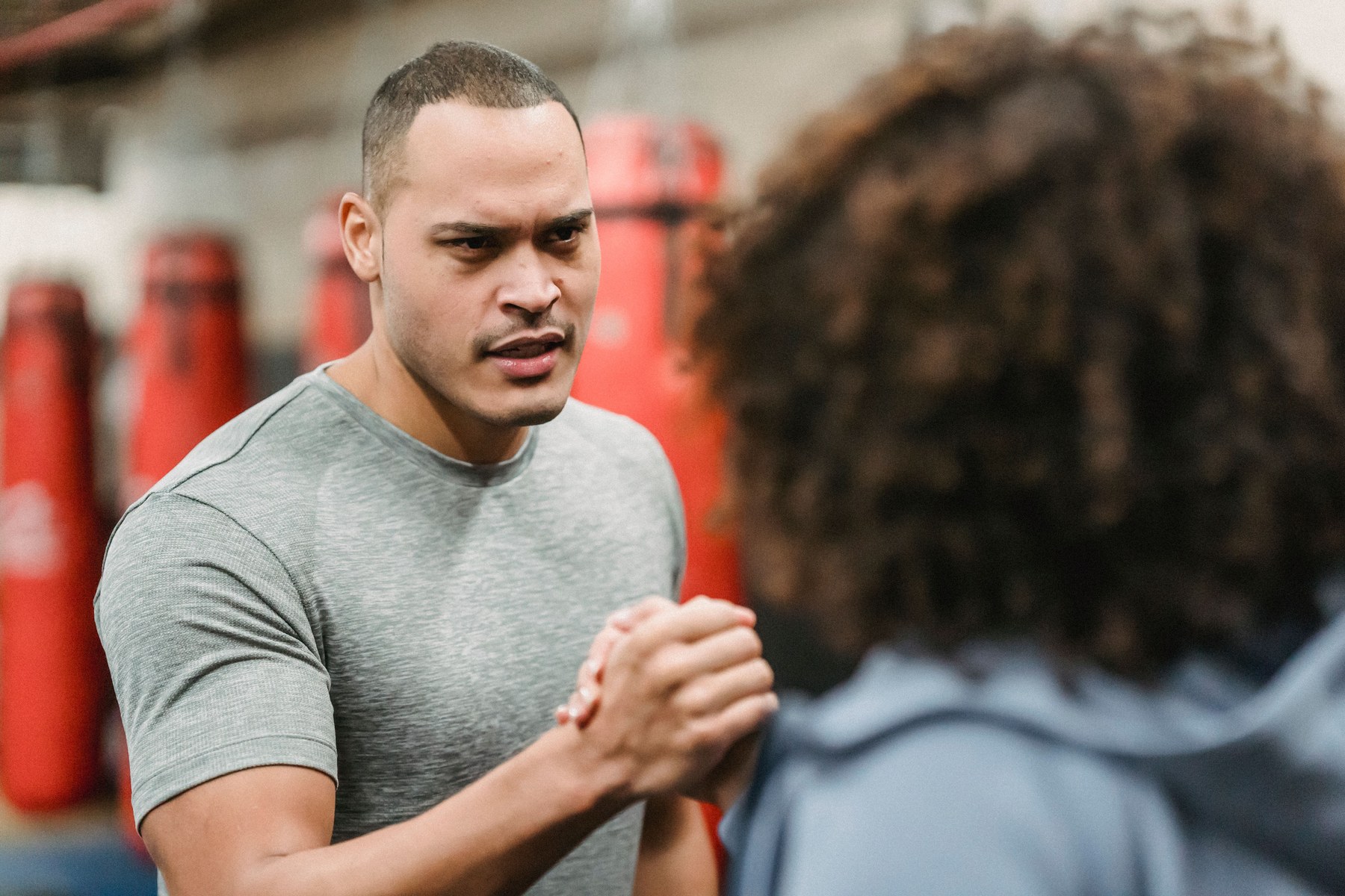 Fitness trainer welcoming a new member with a handshake in a boxing gym