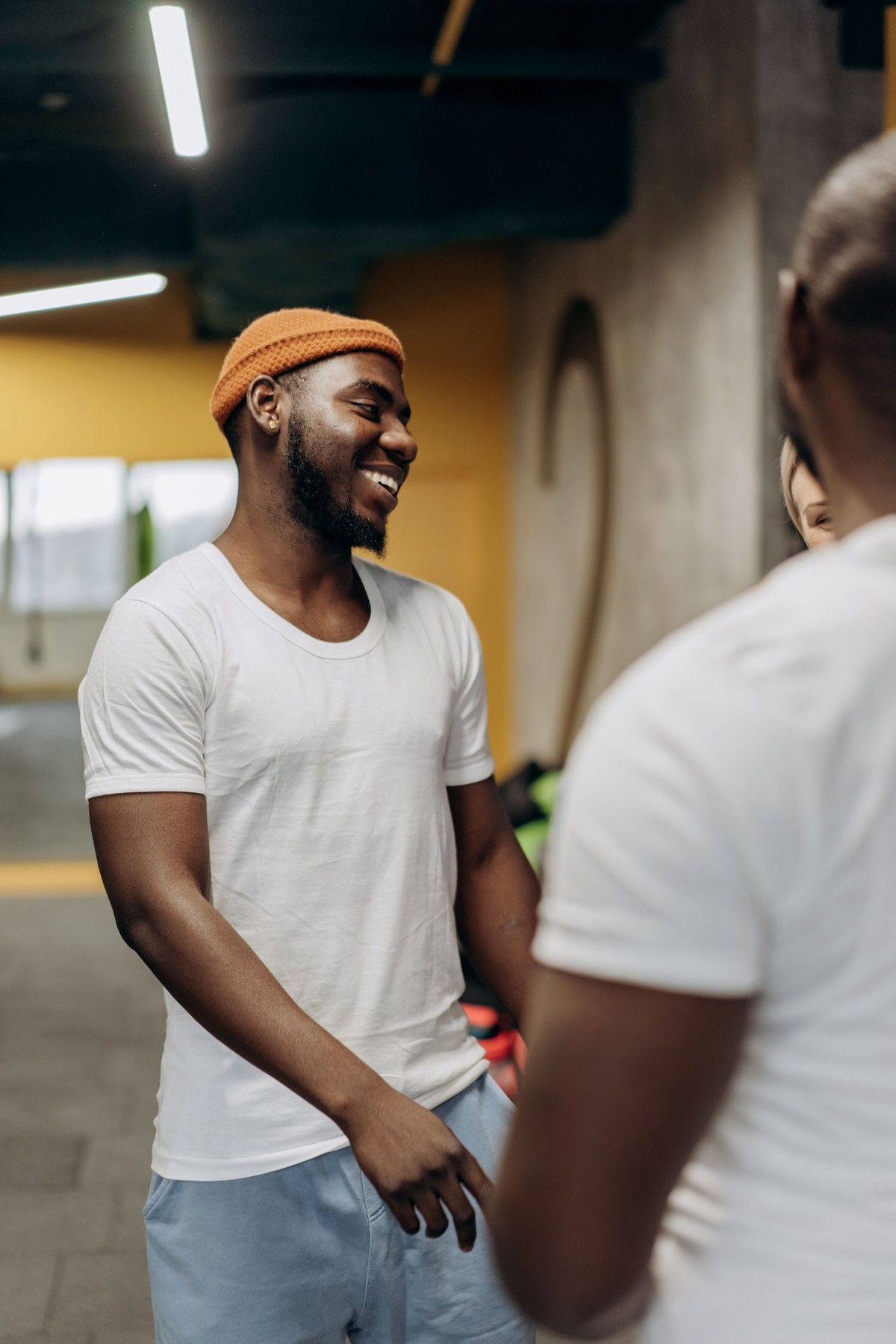Smiling diverse adults chatting together in a modern gym after a workout